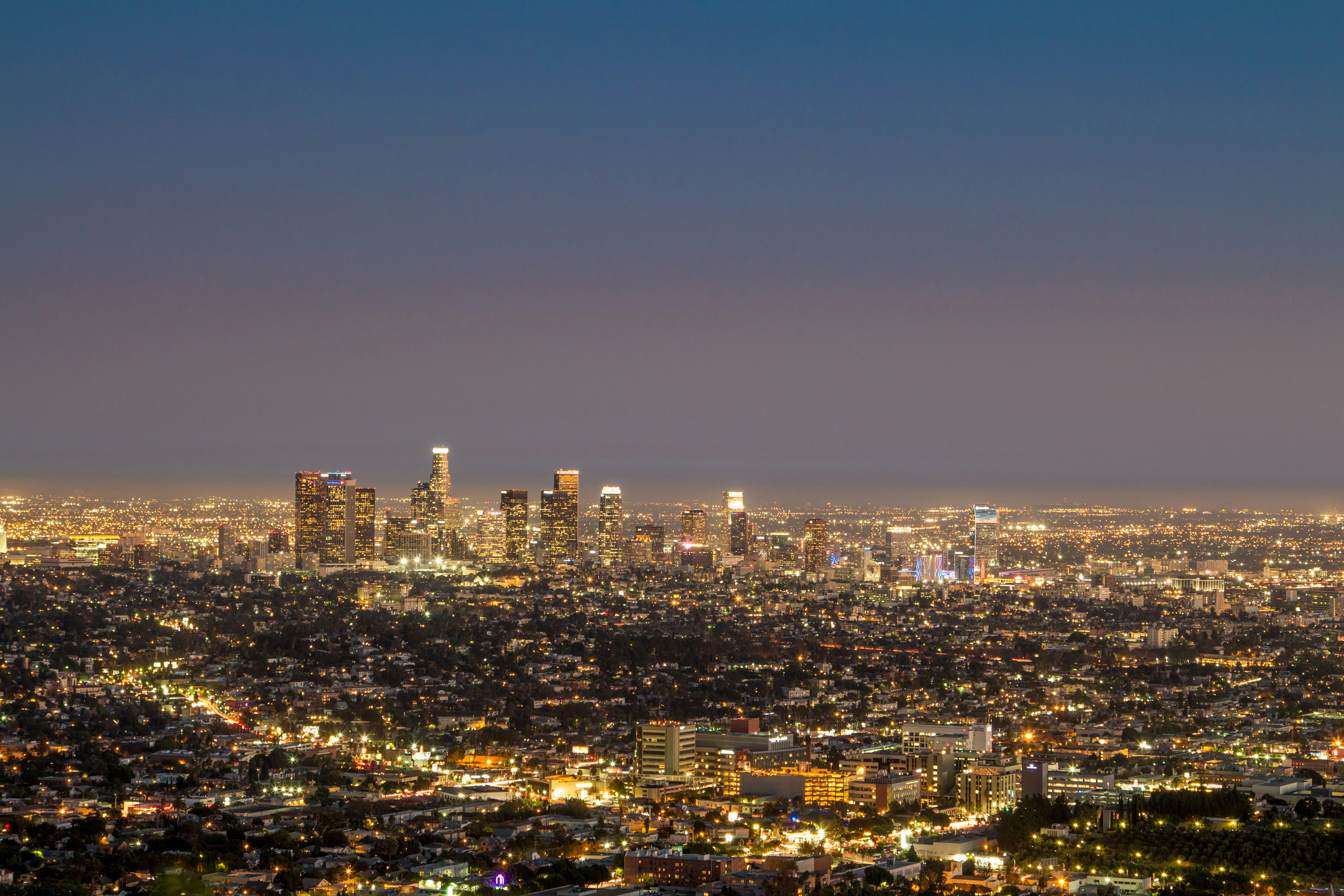 city skyline under blue sky during night time